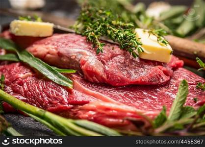 Raw beef steak with herbs and butter for grill or cooking, close up