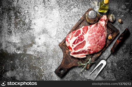 Raw beef steak with spices and rosemary. On rustic background.. Raw beef steak with spices and rosemary.