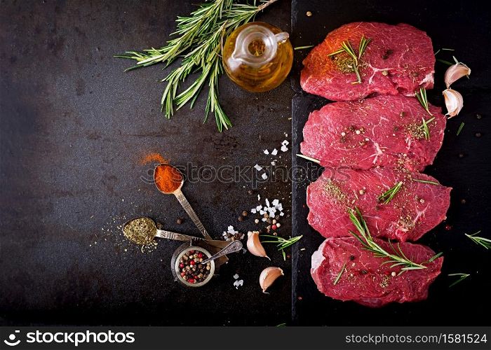 Raw beef steaks with spices and rosemary. Flat lay.Top view