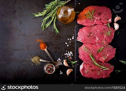 Raw beef steaks with spices and rosemary. Flat lay.Top view