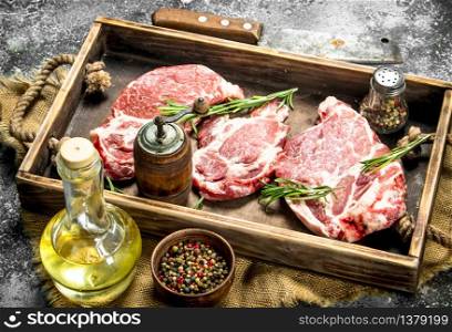 Raw beef with herbs and spices. On rustic background.. Raw beef with herbs and spices.