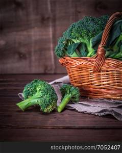 raw broccoli in a brown wicker basket on a wooden table