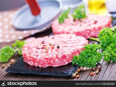 raw burgers on board with salt and spice