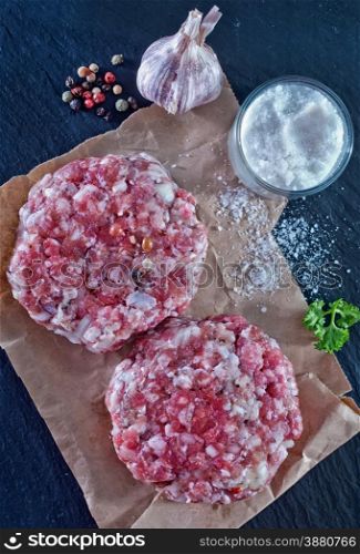 raw burgers on papaer with aroma spice