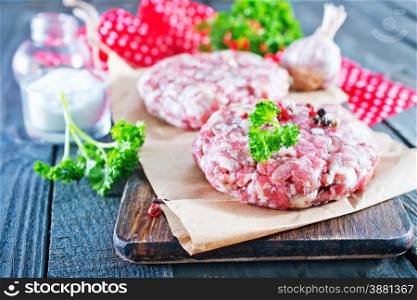 raw burgers with salt and spice on board