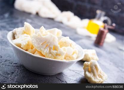 raw cauliflower in bowl and on a table