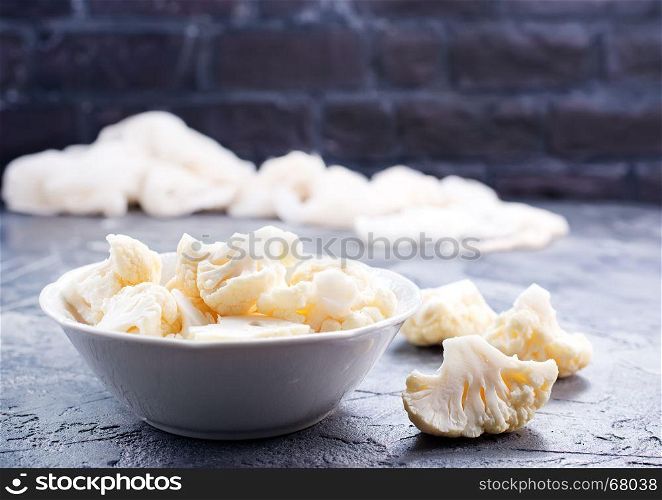 raw cauliflower in bowl and on a table