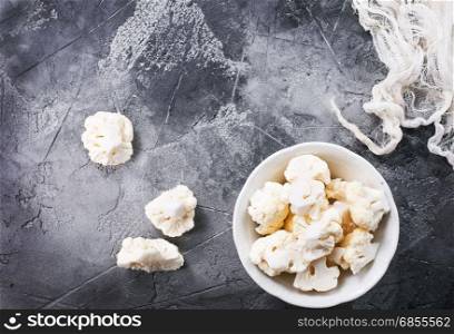 raw cauliflower on plate and on a table
