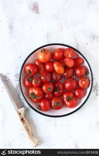 Raw cherry tomato on a white wooden background