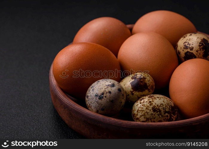 Raw chicken and quail eggs in a brown ceramic bowl on a dark concrete background. Easter preparations