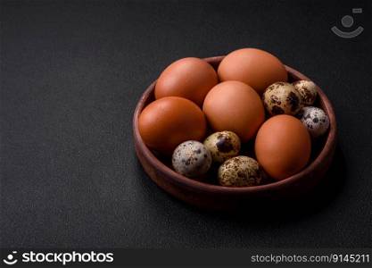 Raw chicken and quail eggs in a brown ceramic bowl on a dark concrete background. Easter preparations