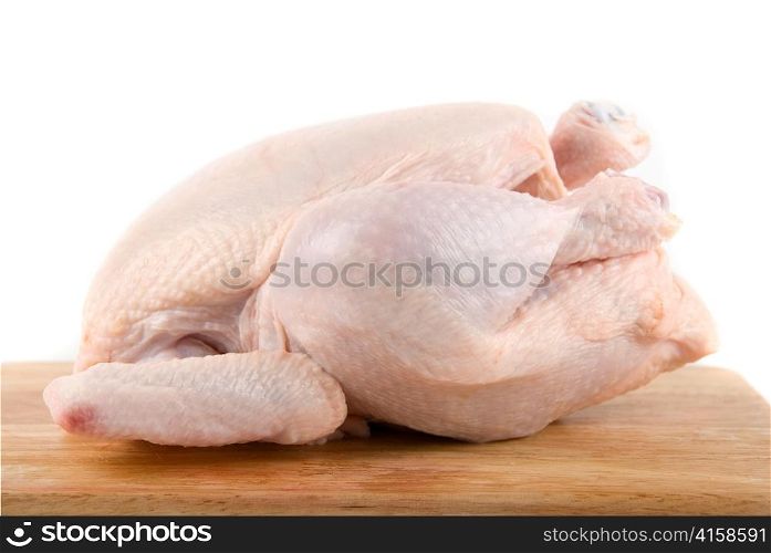 Raw chicken at wood table isolated on white
