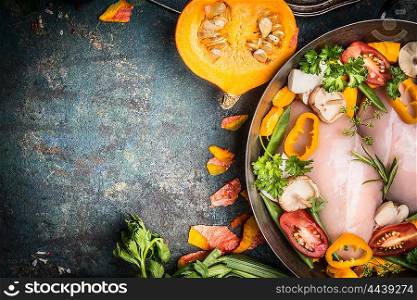 Raw chicken breast in cooking pot with pumpkin and vegetables ingredients on dark rustic background, top view, place for text