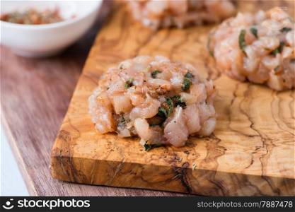 Raw chicken cutlets on olive wood background, selective focus