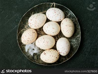 raw chicken eggs on plate and on a table