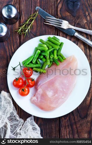 raw chicken fillet and green beans on plate