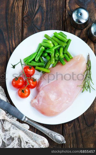 raw chicken fillet and green beans on plate