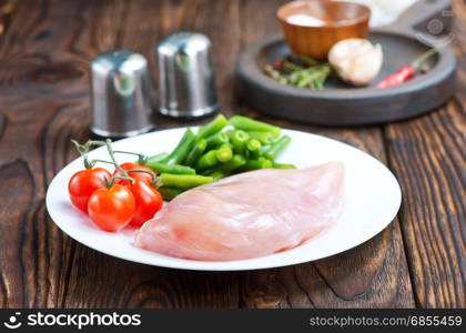 raw chicken fillet and green beans on plate