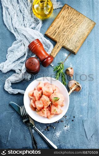 raw chicken fillet in white bowl and on a table