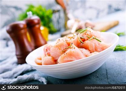raw chicken fillet in white bowl and on a table