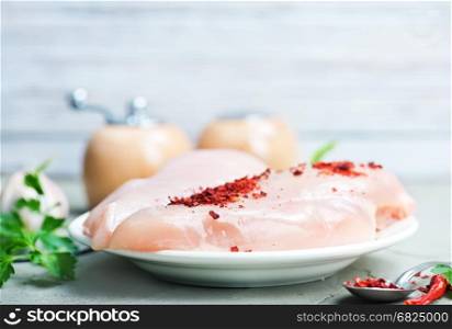 raw chicken fillet with spice on the board