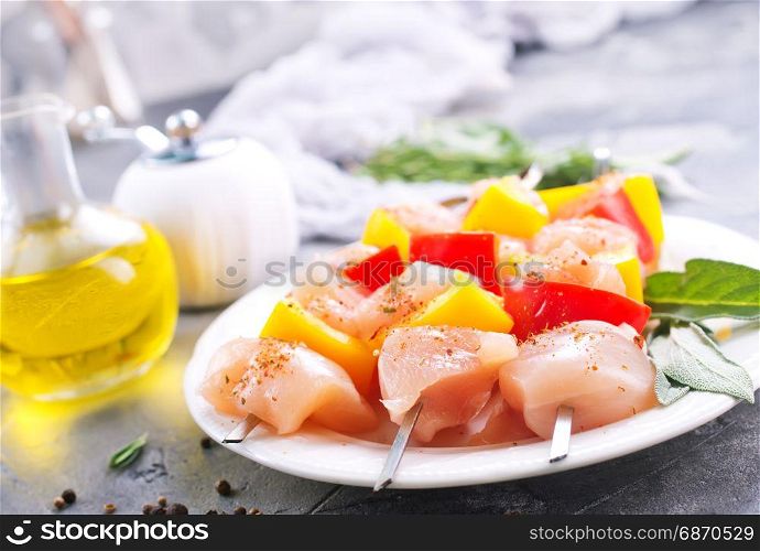 raw chicken kebab with pepper on the plate