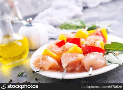 raw chicken kebab with pepper on the plate