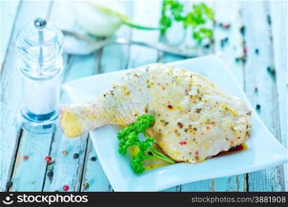 raw chicken leg with spice on the plate