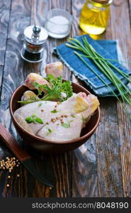 raw chicken legs in bowl and on a table