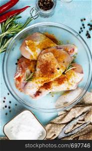 raw chicken legs in bowl, chicken legs with salt and spice