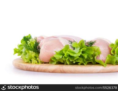 Raw chicken meat with green salad on a wooden board