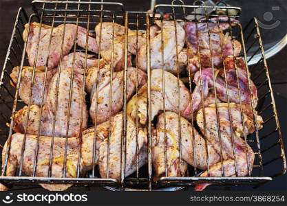 Raw chicken wings with spices on the barbecue