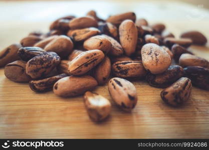 Raw cocoa beans on a wooden board. Raw cocoa beans