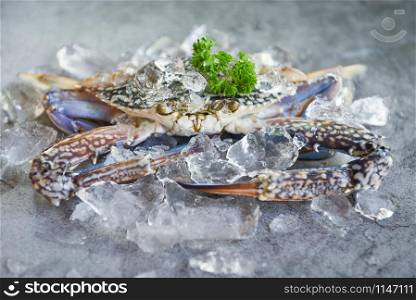 Raw crab on ice with spices on the dark plate background / fresh crab for cooked food at restaurant or seafood market , Blue swimming crab