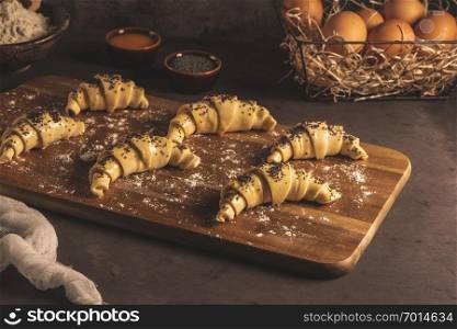 Raw croissant with ingredients on a kitchen countertop.