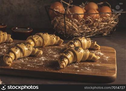 Raw croissant with ingredients on a kitchen countertop.
