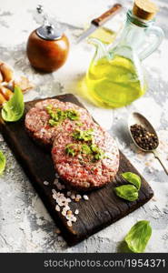 Raw cutlet of minced meat on a wooden cutting board.