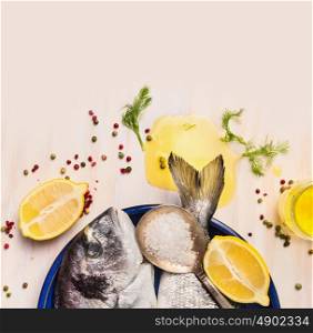 raw dorado fish with oil and lemon on white wooden background, top view, close up