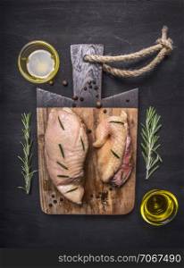 raw duck breast with rosemary, honey and butter on a cutting board on wooden rustic background top view close up