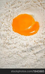 Raw egg in a bunch of flour on the table. On a white background. . Raw egg in a bunch of flour on the table.