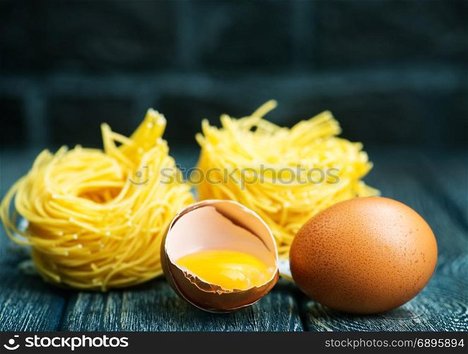 raw egg noodles and yolk on a table