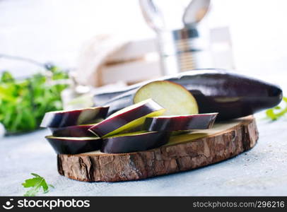 raw eggplant and knife on board, fresh eggplant