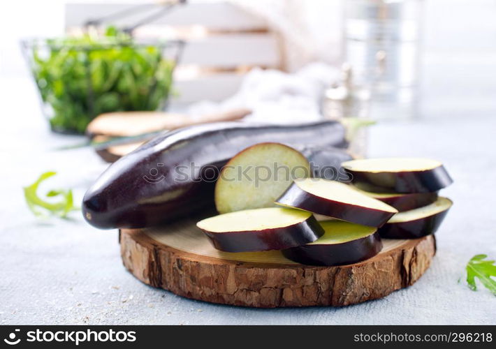 raw eggplant and knife on board, fresh eggplant