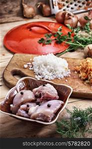 raw fillet of chicken meat and onions in the process of cooking food. raw fillet of chicken meat