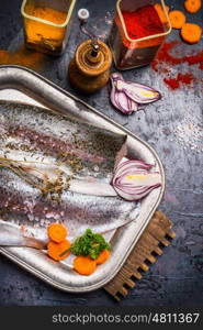 Raw fish fillets with spices, cooking preparation on dark kitchen table , close up