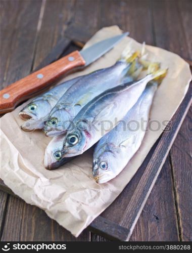 raw fish on paper and on wooden board