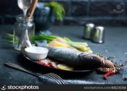 raw fish with lemon and aroma spice on a table