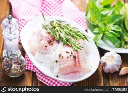 raw fish with spice and pepper on a table