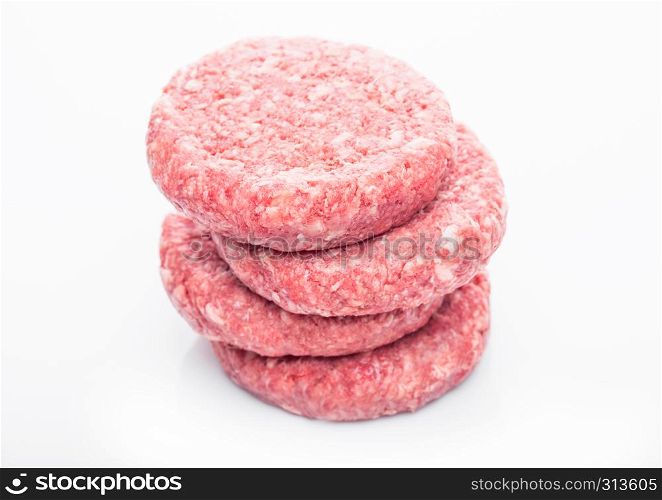 Raw fresh beef burgers on white background with reflection