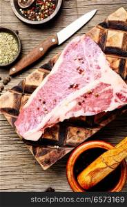Raw fresh marbled meat steak and seasonings on cutting board.Ribeye meat steak. Fresh beef steak